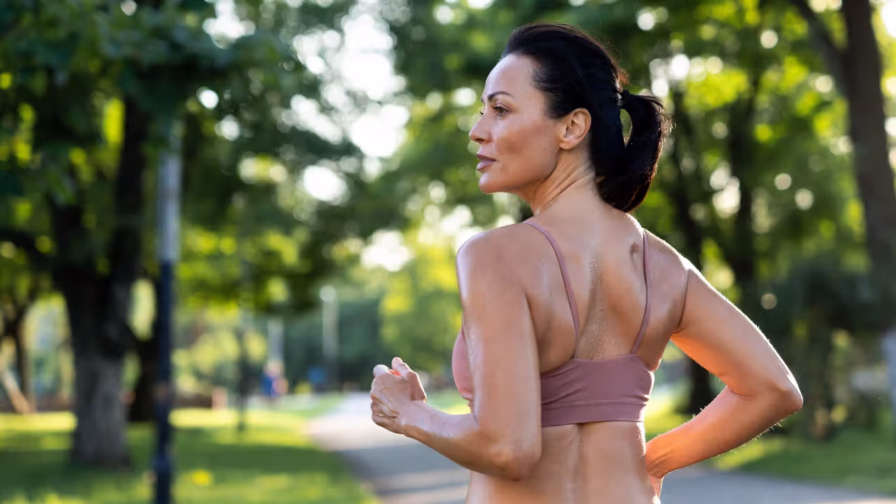 Adult jogging in park in morning light representing healthy habit formation